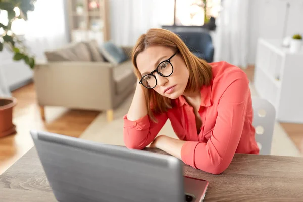 Mujer aburrida con el ordenador portátil que trabaja en casa oficina —  Fotos de Stock
