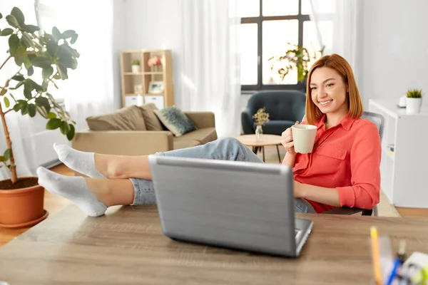 Femme avec ordinateur portable boire du café au bureau à la maison — Photo