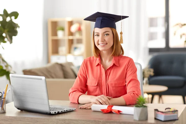 Студентка с ноутбуком и дипломом дома — стоковое фото