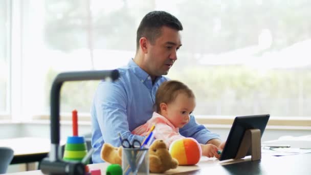 Padre con el bebé trabajando en la tableta PC en casa — Vídeo de stock