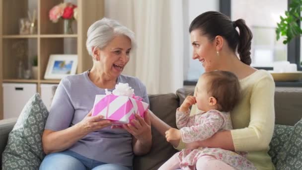 Madre e hija dando regalo a la abuela — Vídeo de stock