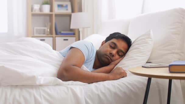 Hombre mirando el teléfono inteligente y vuelve a dormir — Vídeos de Stock