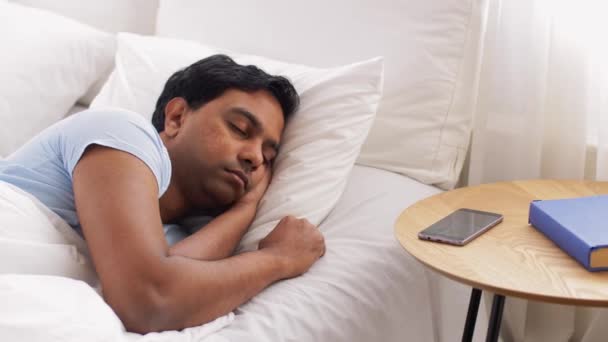 Un bărbat se uită la smartphone și se întoarce la culcare — Videoclip de stoc