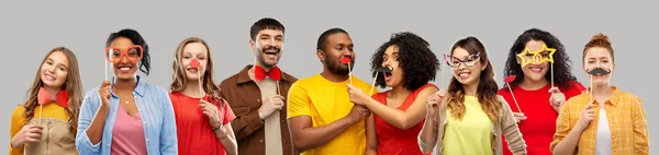 Pessoas sorridentes felizes com adereços de festa — Fotografia de Stock