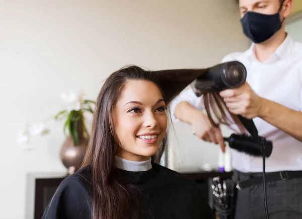 Mulher feliz com estilista fazendo penteado no salão — Fotografia de Stock