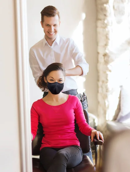 Gelukkig vrouw met stylist maken kapsel in salon — Stockfoto