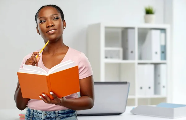 Afrikaans amerikaanse vrouw met notebook op kantoor — Stockfoto