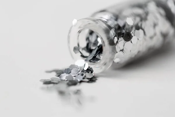 Glitters prata derramado a partir de pequena garrafa de vidro — Fotografia de Stock
