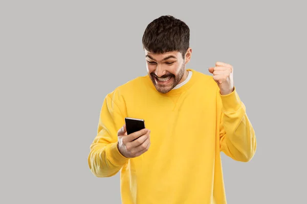 Heureux jeune homme souriant avec smartphone — Photo