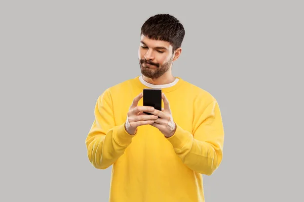 Förbryllad ung man med smartphone — Stockfoto