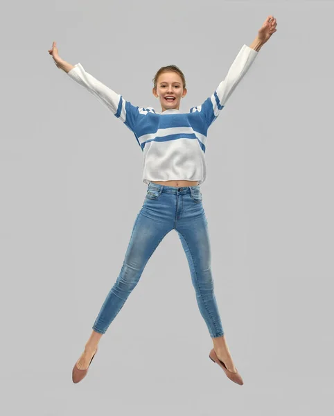 Leende tonåring flicka i pullover hoppar — Stockfoto