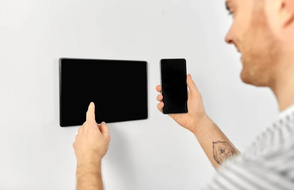 Muž s chytrým telefonem a tabletem PC na smart home — Stock fotografie