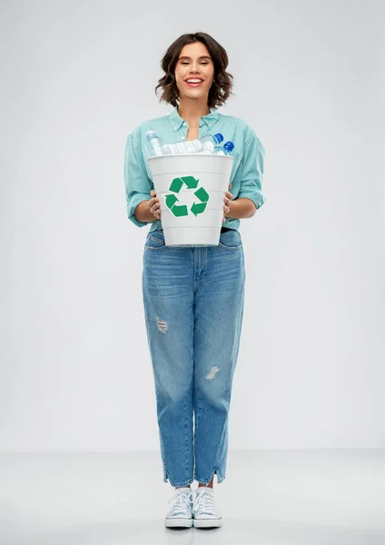 Uśmiechnięta młoda kobieta sortująca odpady z tworzyw sztucznych — Zdjęcie stockowe