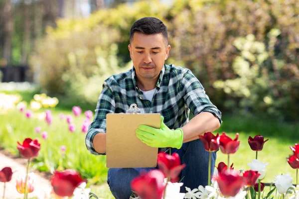 Людина з буфетом і квітами в літньому саду — стокове фото