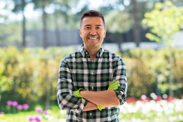 Happy smiling middle-aged man in gloves at garden — Stock Photo, Image