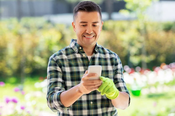 Szczęśliwy człowiek ze smartfonem w ogrodzie letnim — Zdjęcie stockowe