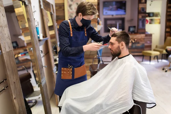 Man and barber with trimmer cutting hair at salon — Stock Photo, Image
