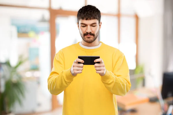 Junger Mann spielt Spiel auf Smartphone — Stockfoto