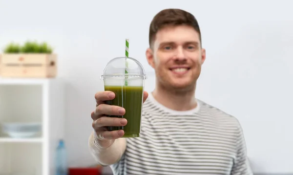 Man dricker grön smoothie från engångskopp — Stockfoto