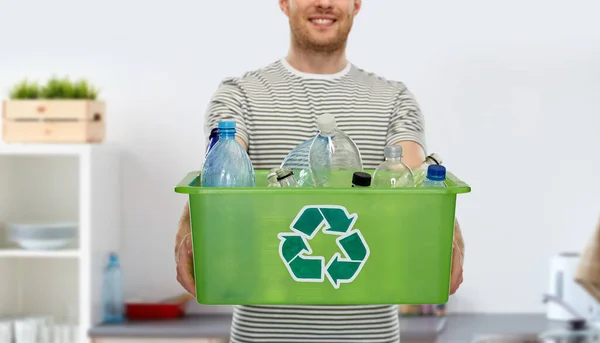 Smiling young man sorting plastic waste — Stock Photo, Image