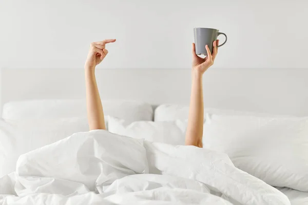 Wanita dengan secangkir kopi berbaring di tempat tidur — Stok Foto