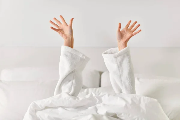 침대에 누워서 스트레칭을 하는 여성의 손 — 스톡 사진