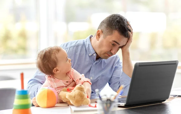 Батько з дитиною працює на ноутбуці в домашньому офісі — стокове фото
