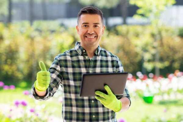 Mann mit Tablet-PC zeigt Daumen nach oben im Garten — Stockfoto