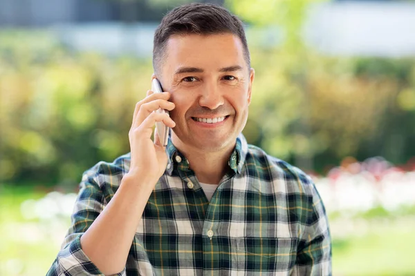 Mutlu adam yaz bahçesinde akıllı telefondan arıyor. — Stok fotoğraf