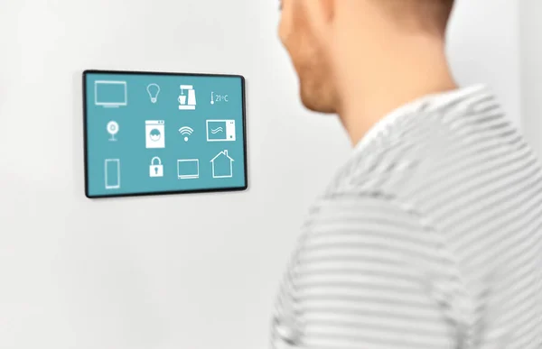 Gelukkig man op zoek naar tablet computer bij smart home Stockfoto