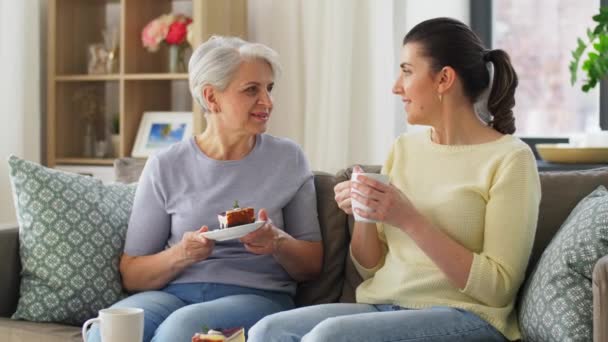 Old mother and adult daughter eating cake at home — Stock Video