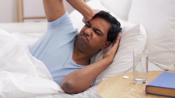 Homme au lit avec médecine et verre d'eau — Video