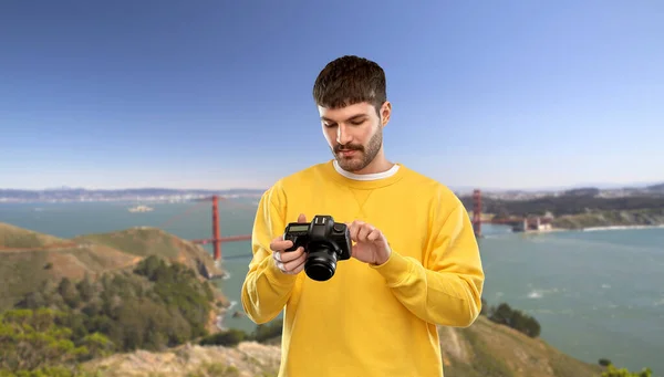 Homme avec caméra sur pont porte dorée — Photo