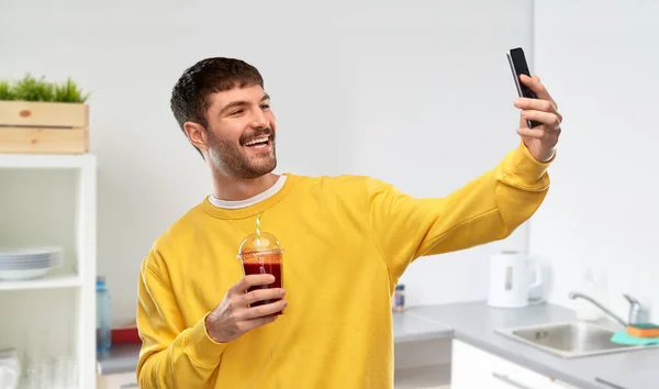 Glad man med smartphone och juice tar selfie — Stockfoto