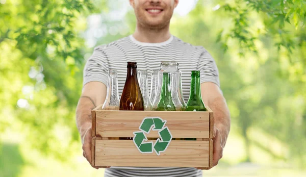 Smiling young man sorting glass waste — Stock Photo, Image