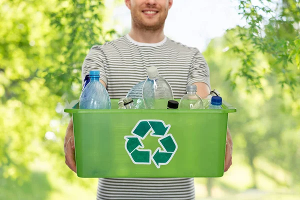 Sorrindo jovem classificando resíduos de plástico — Fotografia de Stock