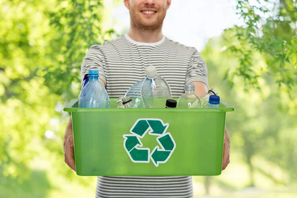 Lächelnder junger Mann beim Sortieren von Plastikmüll — Stockfoto