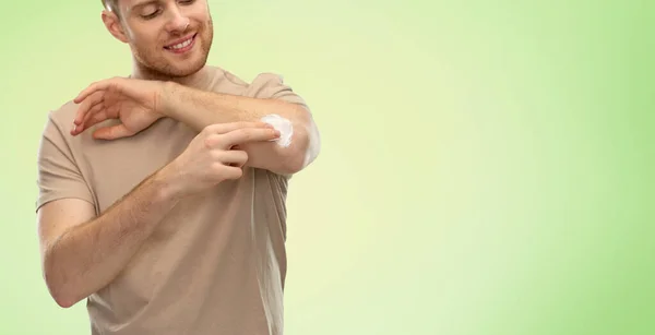 Young man applying pain medication to his elbow — Stock Photo, Image