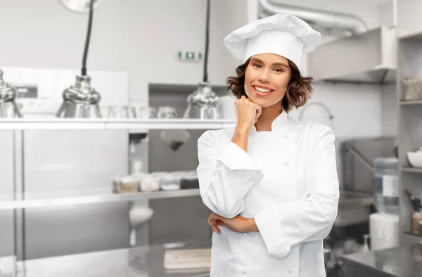 Smiling female chef in toque over restaurant — Stock Photo, Image