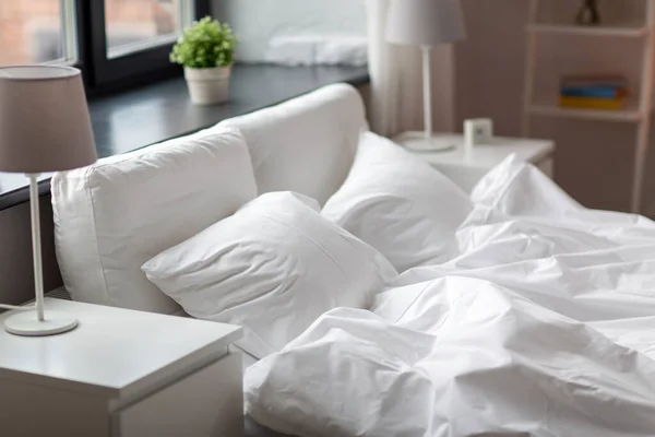 Hangulatos hálószoba fehér ágynemű az ágyon — Stock Fotó