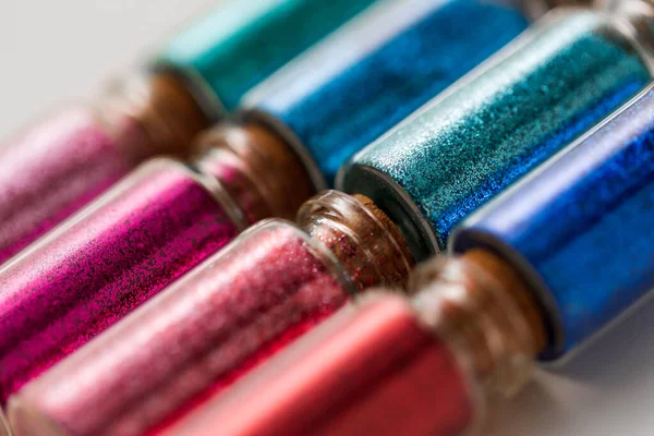 Uppsättning glitter i flaskor över vit bakgrund — Stockfoto