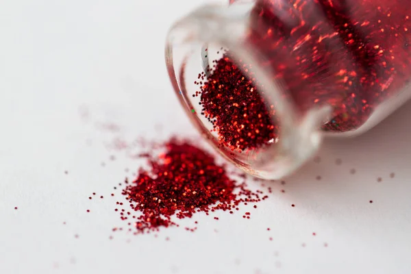 Brilhantes vermelhos derramados a partir de pequena garrafa de vidro — Fotografia de Stock