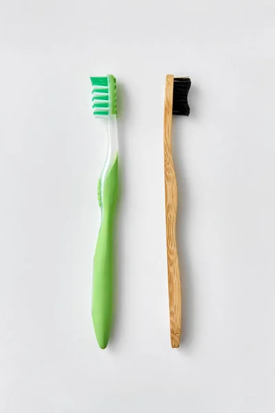 Dřevěný a plastový zubní kartáček na bílém pozadí — Stock fotografie