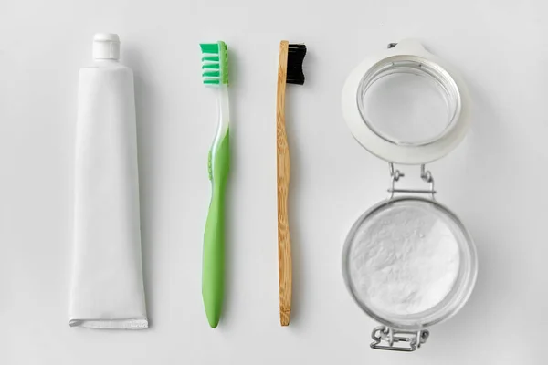 Toothbrushes, toothpaste and soda in jar — Stock Photo, Image