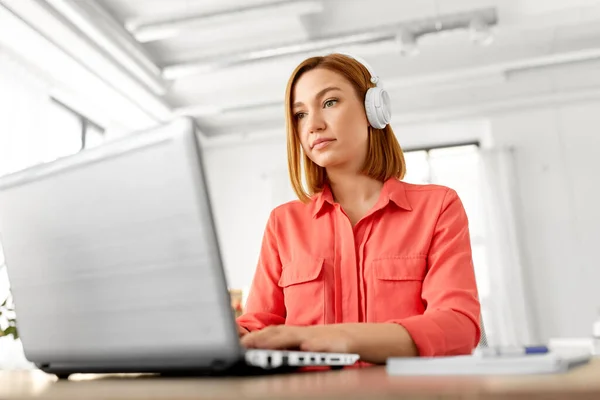 Kobieta w słuchawkach z laptopem pracująca w domu — Zdjęcie stockowe