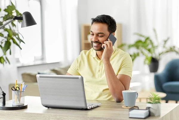 Hombre feliz llamando en el teléfono inteligente en la oficina en casa — Foto de Stock