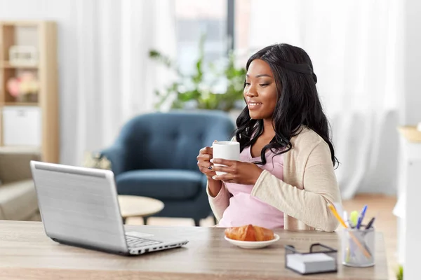 Mujer feliz con el ordenador portátil y café en la oficina en casa — Foto de Stock