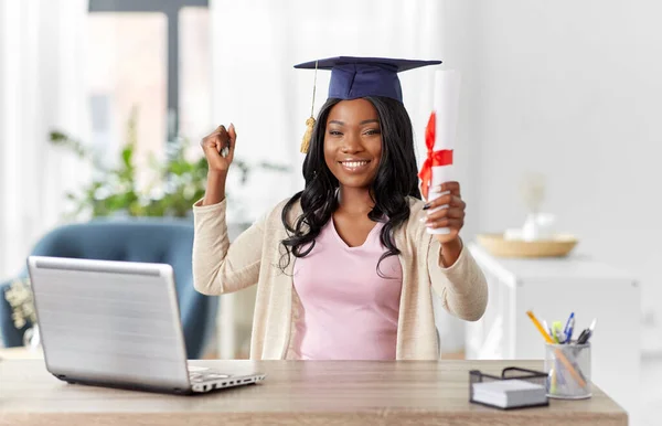 Afgestudeerde student met laptop en diploma thuis — Stockfoto