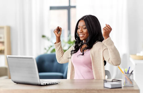 Femme heureuse avec ordinateur portable travaillant au bureau à la maison — Photo