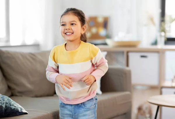 Счастливая улыбающаяся маленькая девочка дома — стоковое фото
